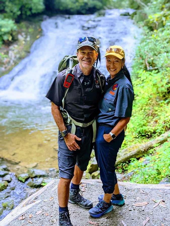 Mark and Jonie pose in front of a waterfall.