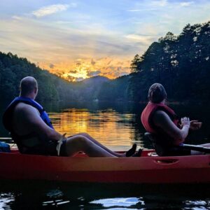 Two people on a kayak enjoy the sunset on Lake Fontana.